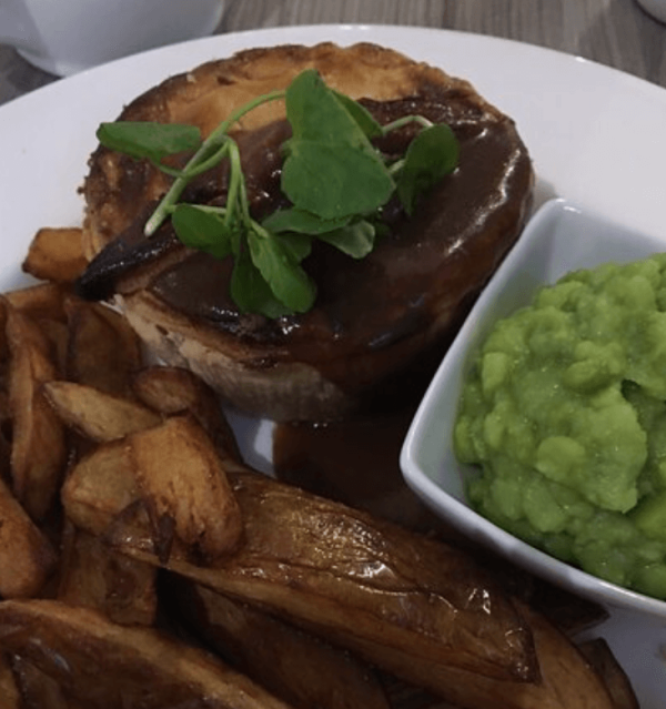 Juicy steak served with crispy chips and creamy mashed peas at Wharncliffe Restaurant in Rotherham.