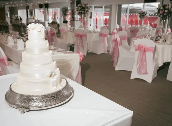A beautifully decorated wedding cake and delicious food spread inside the AESSEAL New York Stadium.