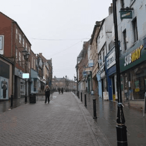 A bustling high street in the heart of Rotherham town centre, filled with shops and pedestrians.